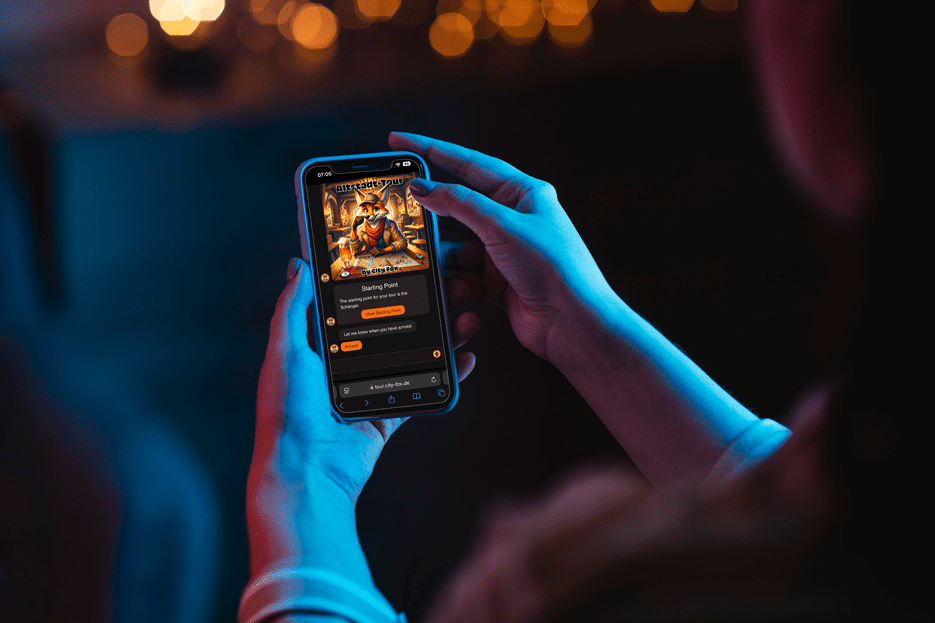 Person hält Smartphone mit interaktiver Stadtführung vom City-Fox